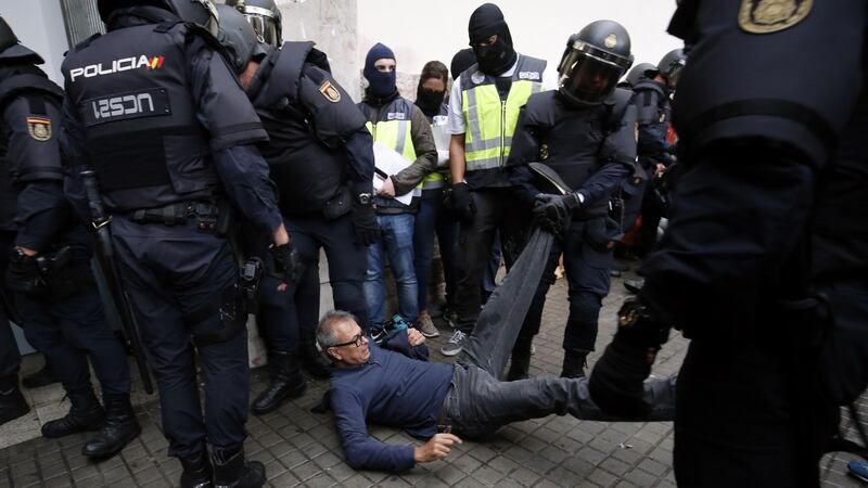 Spanish police clear the entrance of a polling station in Barcelona. Photograph: Pau Barrena/AFP/Getty Images