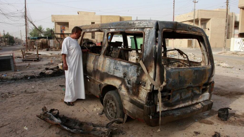 A man looks at a damaged vehicle a day after a car bomb attack in Baghdad earlier this week. More than 66 people have died after two other bomb attacks in Iraq yesterday. Photograph: Ahmed Malik/Reuters.