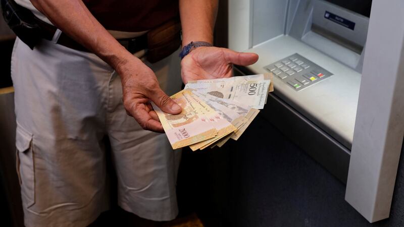 A man displays Bolivar notes after withdrawing them from an automated teller machine in Caracas, Venezuela, this weekend. Photograph: Marco Bello/Reuters
