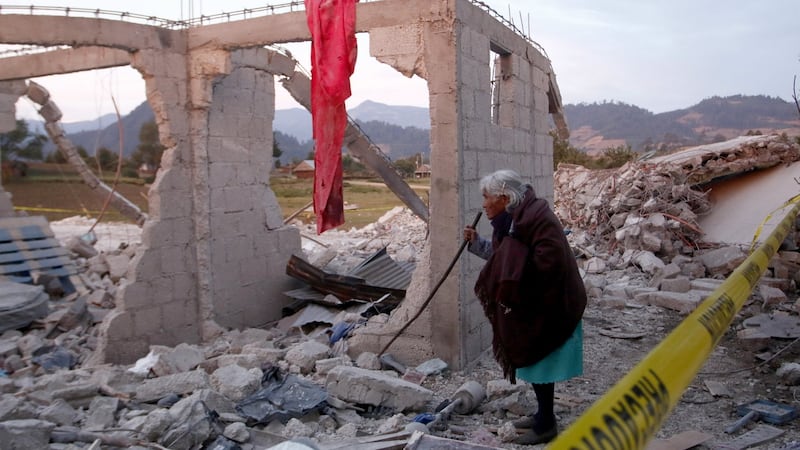 A woman views debris at the site of a fireworks explosion at a house in the municipality of Chilchotla, Puebla, Mexico. Photograph: Francisco Guasco/EPA