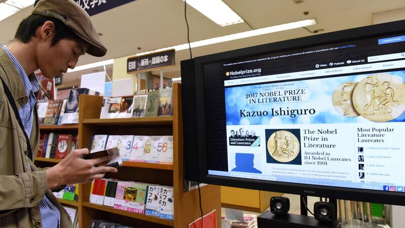 A man reads a book written by Japanese-born British novelist Kazuo Ishiguro at a book store in Tokyo today, after he won the Nobel  Prize in Literature. Photograph:  Kazuhiro Nogikazuhiro NOgi/AFP/Getty Images