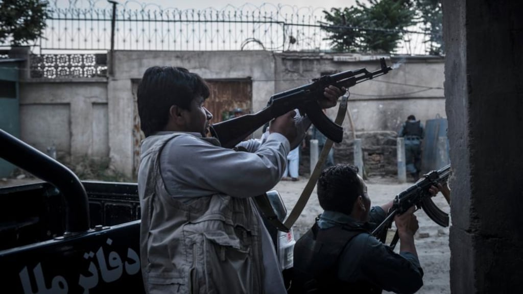 Afghan police officers engage in a battle with insurgents in Kabul, Afghanistan, today. Photograph: Sergey Ponomarev/The New York Times