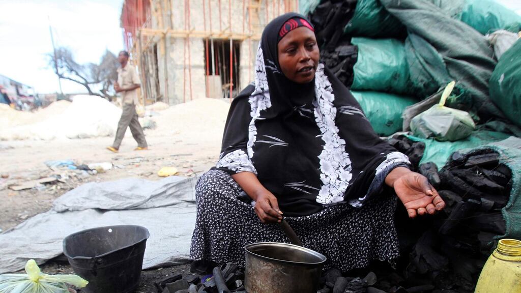A woman sells charcoal along a street near Bakara market in Mogadishu. Photograph: Ismail Taxta/Reuters