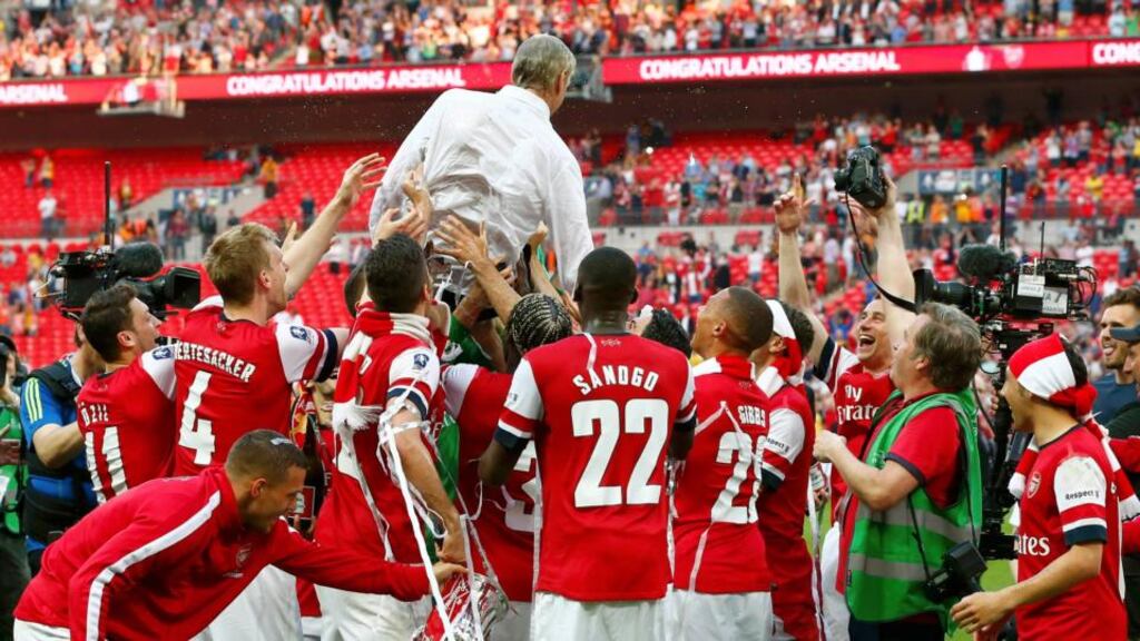 Arsenal manager Arsene Wenger is lifted by his players as they celebrate their victory against Hull City in the FA Cup final at Wembley Stadium on Saturday. Photograph: Reuters