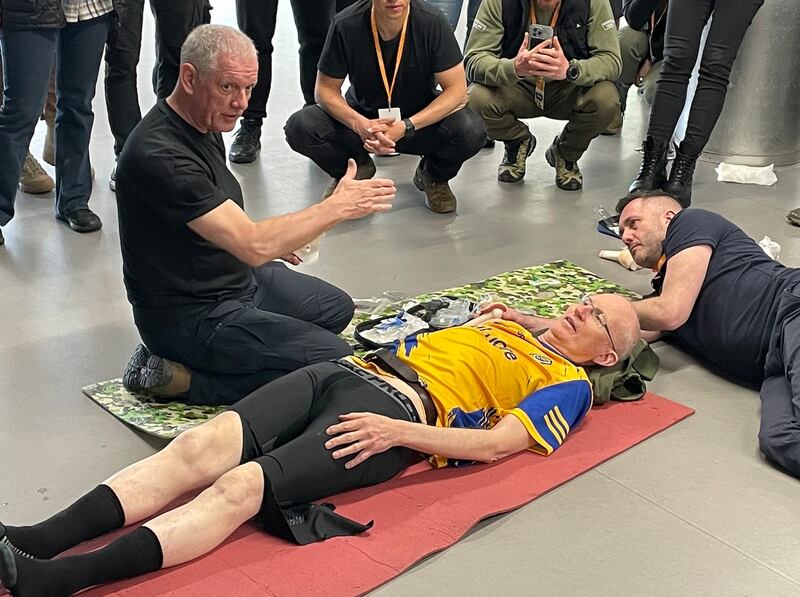 Irish paramedic Ben Heron (left) demonstrates a procedure on Prof Chris Fitzpatrick of UCD with help from paramedic Keith Hayes during a course for Ukrainian combat medics in Kyiv. Photograph: Daniel McLaughlin