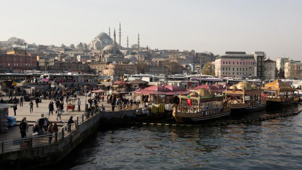 Pedestrians walk along the bank of the Bosphorus strait as the minarets of mosques stand beyond in the Eminonu district of Istanbul, Turkey.   There are fears Turkey’s troubles will  spread across the world’s emerging markets. Photograph: Kerem Uzel/Bloomberg