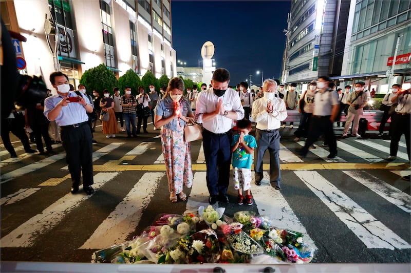 People pray at the scene where Shinzo Abe was shot. Photograph: Kyodo News/AP