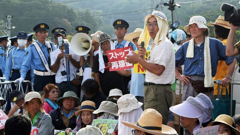 People stage a rally against the restarting of the nuclear reactor outside the gates of the Kyushu Electric Power Sendai nuclear power plant. Photograph: Jiji Press/AFP/Getty Images