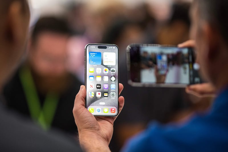 Examining an Apple iPhone 15 Pro during Apple's launch event on Tuesday. Photograph: Nic Coury/AFP