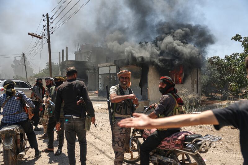 Bedouin fighters gather in front a burning shop. Photograph: Ghaith Alsayed/AP