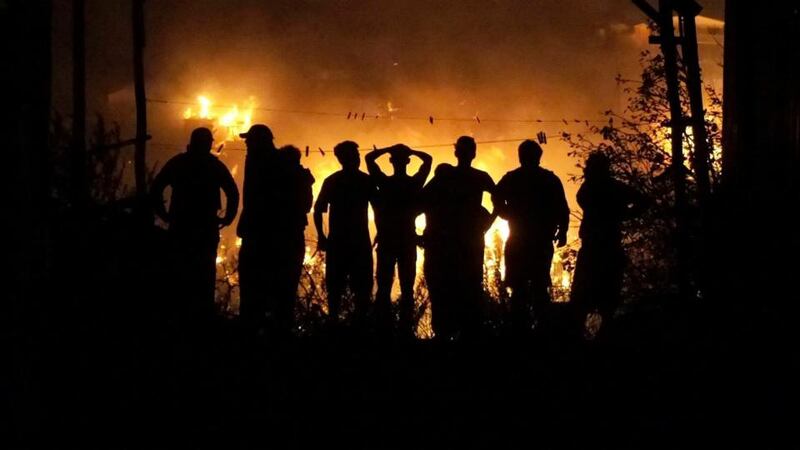 People watch as houses burn in   the city of Valparaiso, Chile. Photograph: EPA