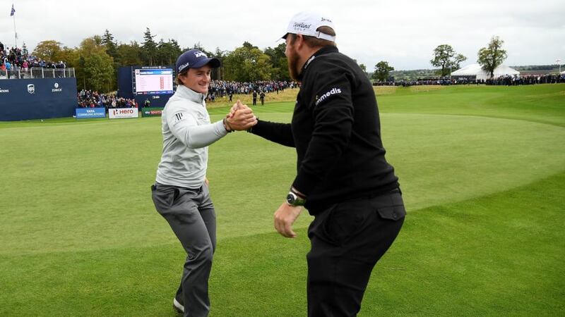 Dunne is congratulated by Lowry as he leaves the 18th green. Photo: Ross Kinnaird/Getty Images