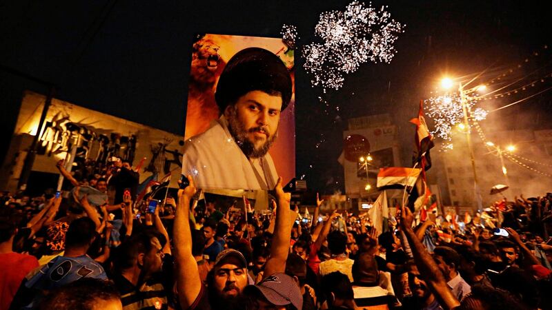 Supporters of Shia  cleric Muqtada al-Sadr carry his image as they celebrate in Tahrir Square, Baghdad last Sunday. Photograph:  Hadi Mizban/AP