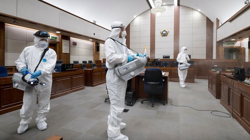 Sanitary workers clad in protective gear disinfect the Seoul Central District Court in southern Seoul, South Korea, on Friday Photograph: Yonhap/EPA