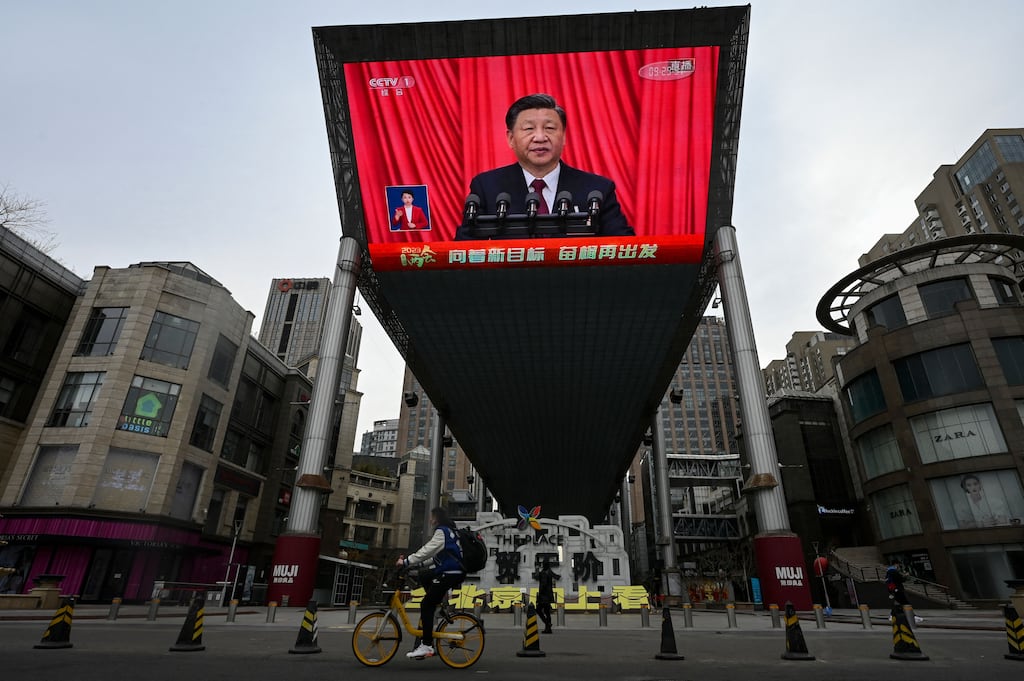 An outdoor screen shows live news coverage on a street in Beijing of China's president Xi Jinping delivering a speech during the closing session of the National People's Congress. Photograph: Jade Gao/AFP