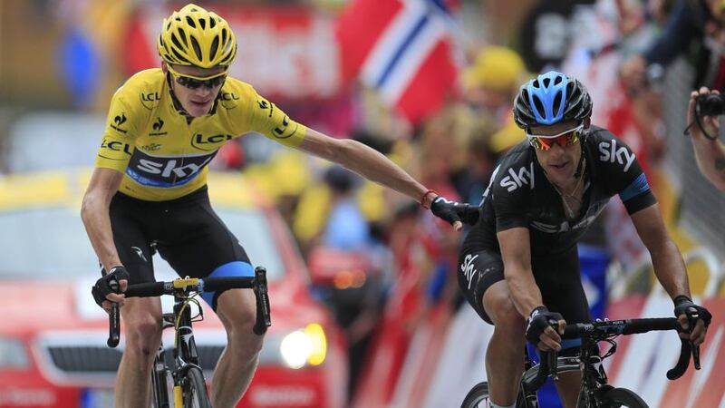 Chris Froome, wearing the overall leader’s yellow jersey, says thanks to team-mate Richie Porte of Australia, right, as they cross the finish line of the 18th stage of the Tour de France on Alpe-d’Huez. Photograph: Peter Dejong/AP