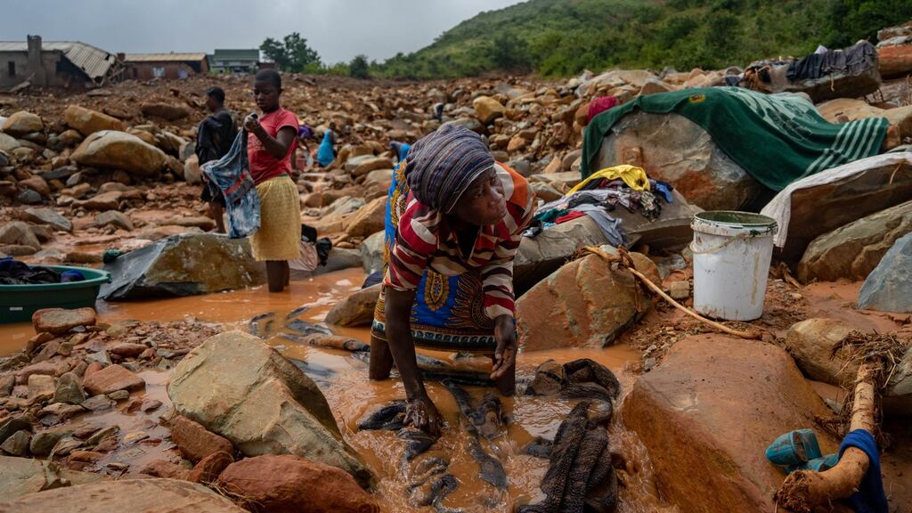 An elderly woman washes her belongings in the mud, in Chimanimani, Zimbabwe, earlier this week. An area of 394sq km had been flooded in the wake of a powerful cyclone. Photograph: Zinyange Auntony/AFP/Getty Images