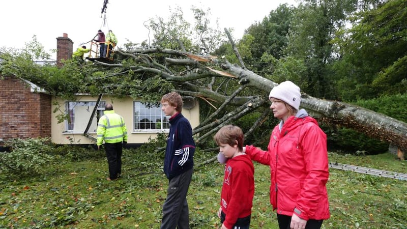 Brenda Coughlan with her sons Jack and Brendan (left) at their home as the fallen tree is removed yesterday at Clonfert, Co Galway. Photograph: Joe O’Shaughnessy.