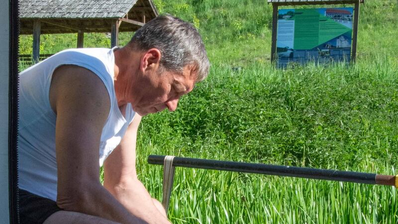 A fisherman beside the Nemunas shows June Molloy his catch