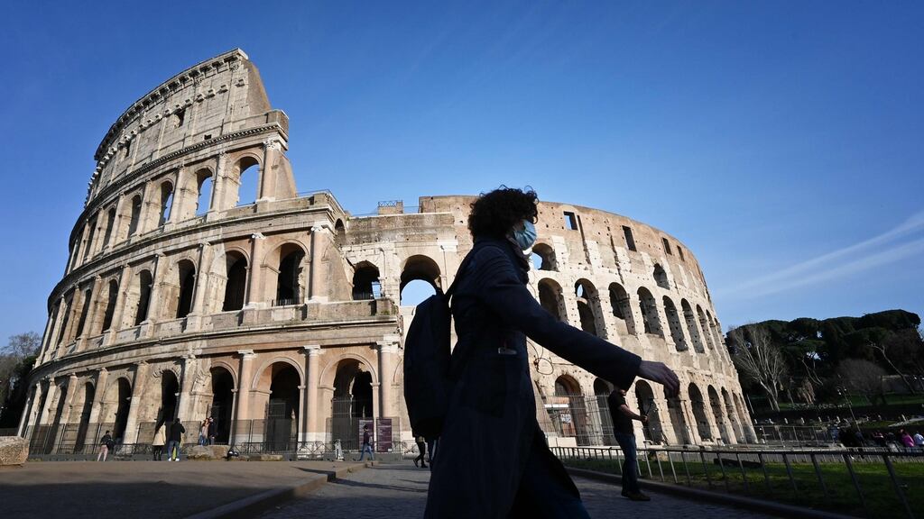 A tourist wearing a respiratory mask as part of precautionary measures against the spread of the new COVID-19 coronavirus, walks past the closed Colisseum monument in Rome on March 10, 2020.(Photo by ALBERTO PIZZOLI/AFP via Getty Images)