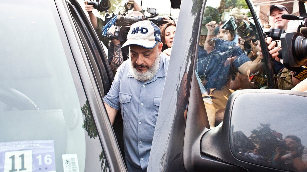 Mohammad Rahami, father of Ahmad Khan Rahami, is escorted by law enforcement past reporters to his car, in front of his home on Elmora Avenue in Elizabeth, New Jersey. Photograph: Bryan Anselm/The New York Times