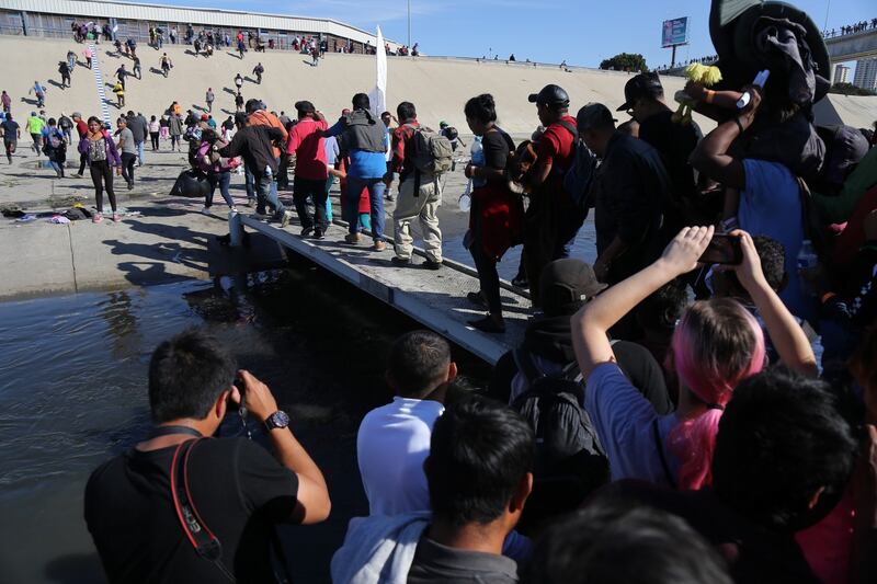 A group of people try to cross El Chaparral border crossing, in Tijuana. A group of migrants from the caravan of central Americans who advanced today towards the San Ysidro (US) gateway deviated from the planned route to try to cross the border wall by other points, while the US border police threw tear gas. Photograph: David Guzman/EPA