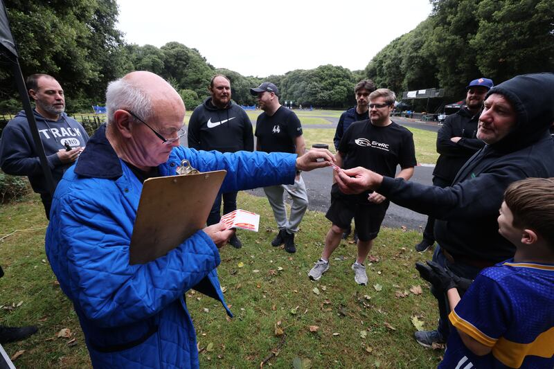Denis Fox hands out car numbers to the drivers