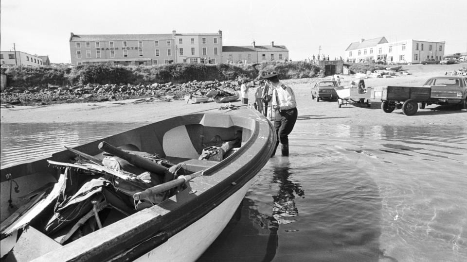 Victims of the bombing:  a garda pulls ashore a rowing boat containing wreckage of Shadow V, Lord Mountbatten’s boat, at Mullaghmore. Photograph: Pat Langan