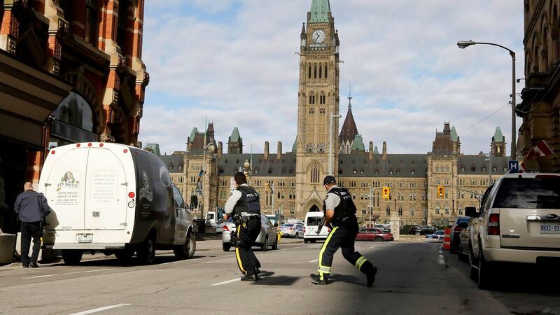 Armed RCMP officers race across a street on Parliament Hilll following a shooting incident in Ottawa today. Photograph: Chris Wattie/Reuters