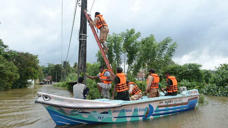 Sri Lankan electricity board workers disconnect a main power line amid flooding in Nagoda in the district of Kalutara. Photograph: Lakruwan Wanniarachchi/AFP/Getty Images