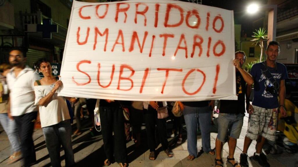 People hold a banner, which reads: ’Humanitarian corridor now’, during a procession in memory of victims of the shipwreck of a migrant boat on the Italian island of Lampedusa last night. Photograph: Antonio Parrinello/Reuters