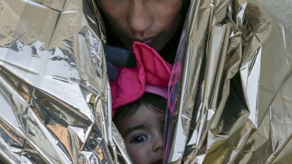 A migrant, wrapped with her child in a thermal blanket, waits for a train to Croatia, at a train station in Presevo, Serbia. Photograph: Marko Djurica/Reuters