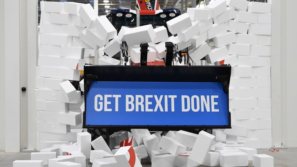 British prime minister Boris Johnson drives a Union flag-themed JCB through a fake wall while on the election campaign trail in Uttoxeter on Tuesday. Photograph: Stefan Rousseau/PA Wire