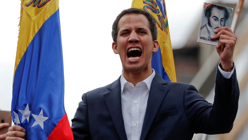 Juan Guaidó, president of Venezuela’s national assembly, holds a copy of the Venezuelan constitution during a rally against president Nicolás Maduro’s government in Caracas on Wednesday. Photograph: Carlos Garcia/Reuters