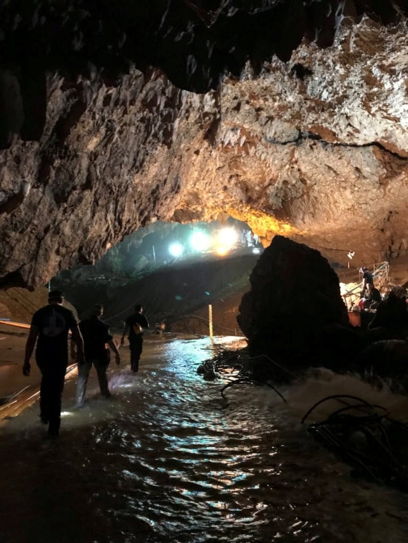 Rescue personnel walk in a cave at the Tham Luang cave complex during a mission to evacuate the remaining members of a soccer team trapped inside.