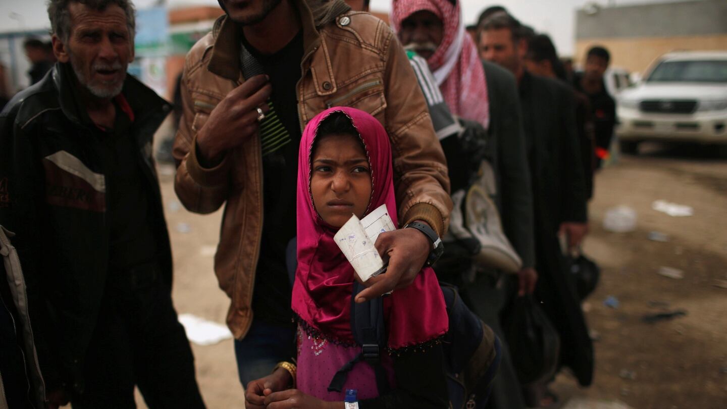 Displaced Iraqis wait to get food supplies  in western Mosul on Tuesday. Photograph: Suhaib Salem/Reuters