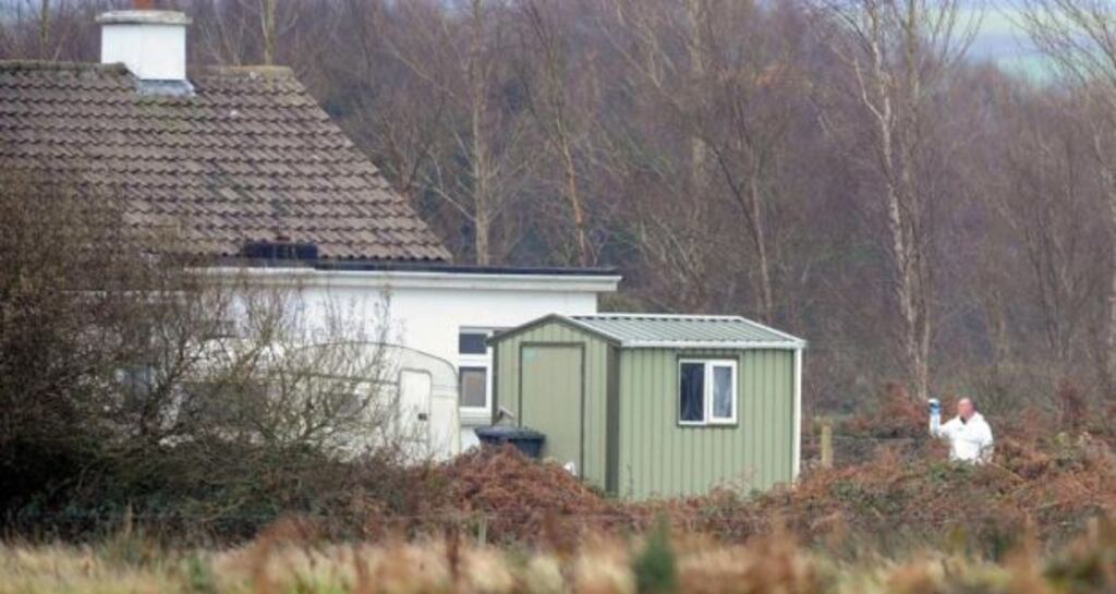 Gardai in the garden of the house at Ballinageragh, Lixnaw, Co Kerry where the body of a woman in her 50s, was found.