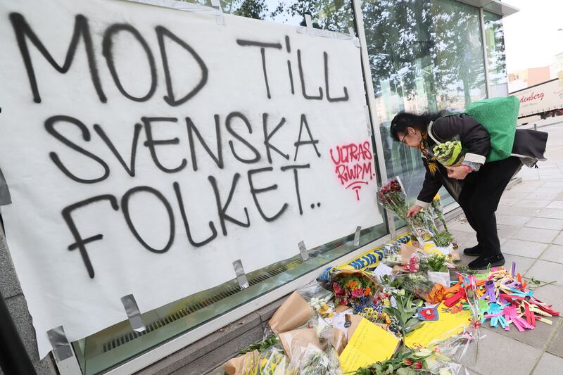 A woman lays flowers next to a banner reading "Courage to the Swedish people" following Monday's terrorist attack against Swedish soccer supporters in Brussels. Photograph: Benoit Doppagne/Getty/AFP