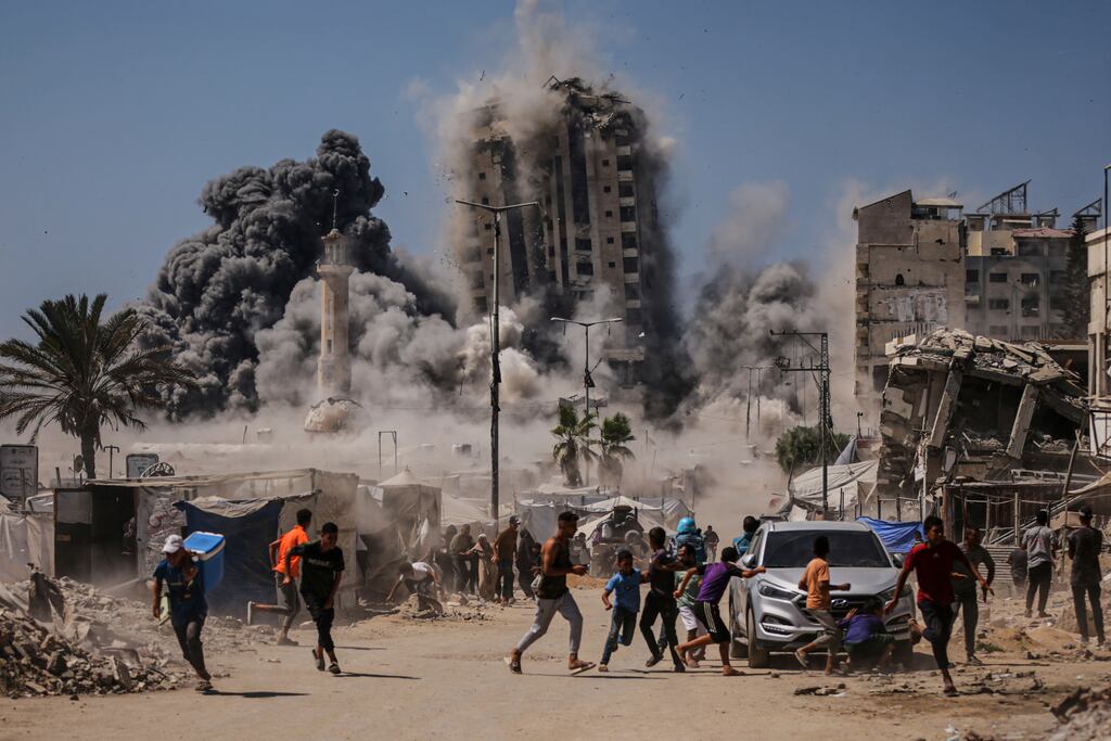 Palestinians run for cover during an Israeli airstrike on a high-rise building in Gaza City. Photograph: Yousef Al Zanoun/AP