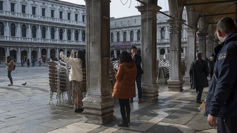 Tourists stand by closed cafes and stacked up chairs in Piazza San Marco following recent floods in Venice, Italy. Photograph: Bloomberg