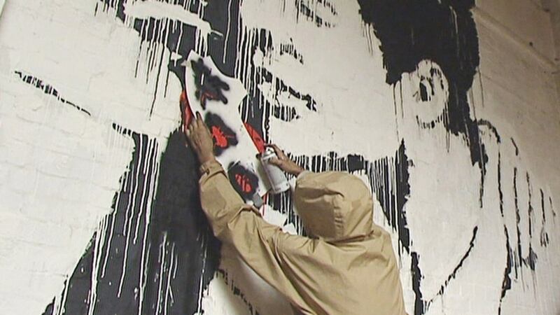 Artist purporting to be Banksy stencils an insect on to a wall. Photograph: ITV News/PA