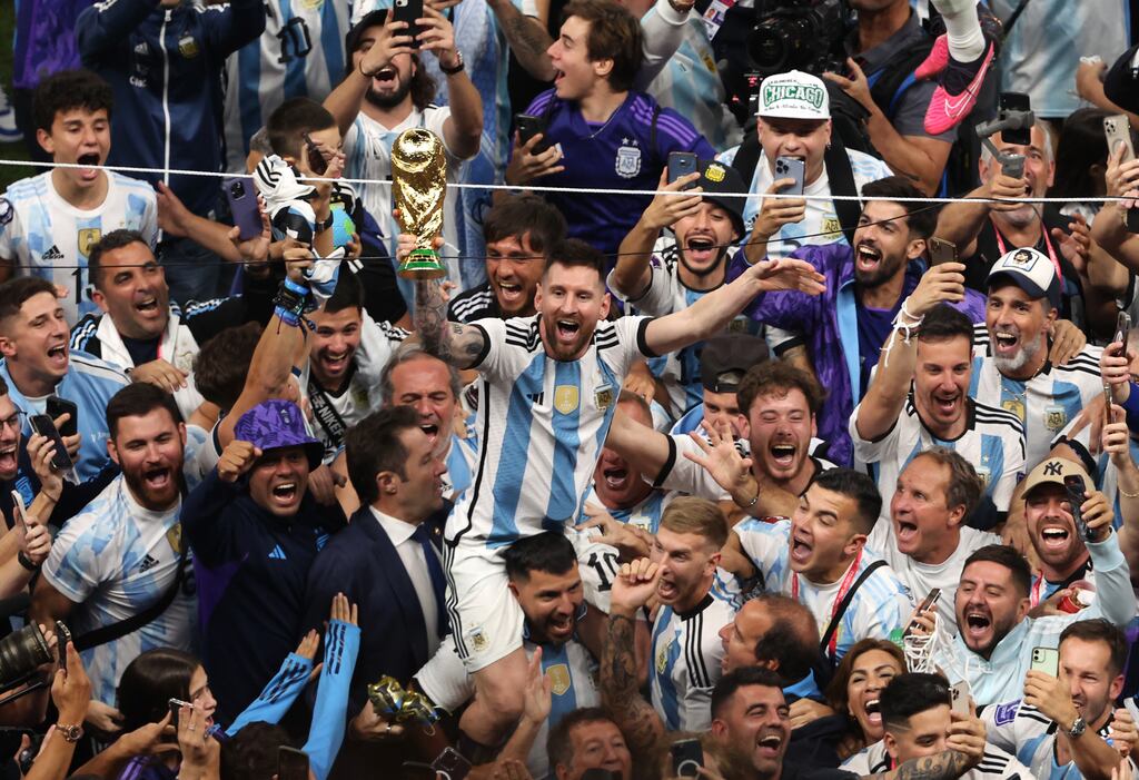 Argentina captain Lionel Messi celebrates with the World Cup trophy following the penalty shoot-out win over France at Lusail Stadium. Photograph: Alex Pantling/Getty Images