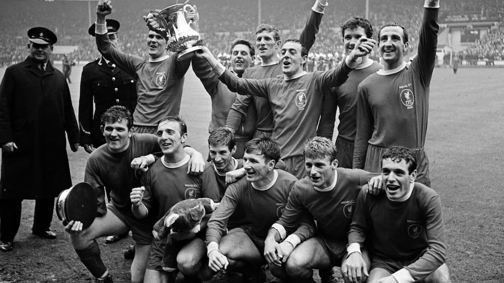The Liverpool team, back row, left to right, Ron Yeats, Gordon Milne, Willie Stevenson, Ian St John, Chris Lawler and Gerry Byrne, front row, left to right, Tommy Lawrence, Peter Thompson, Geoff Strong, Tommy Smith, Roger Hunt and Ian Callaghan celebrate with the trophy after the Liverpool v Leeds United FA Cup Final held at Wembley Stadium, London on the 1st May 1965. Liverpool won the match 2-1 after extra time. Photograph: Bob Thomas/Getty Images
