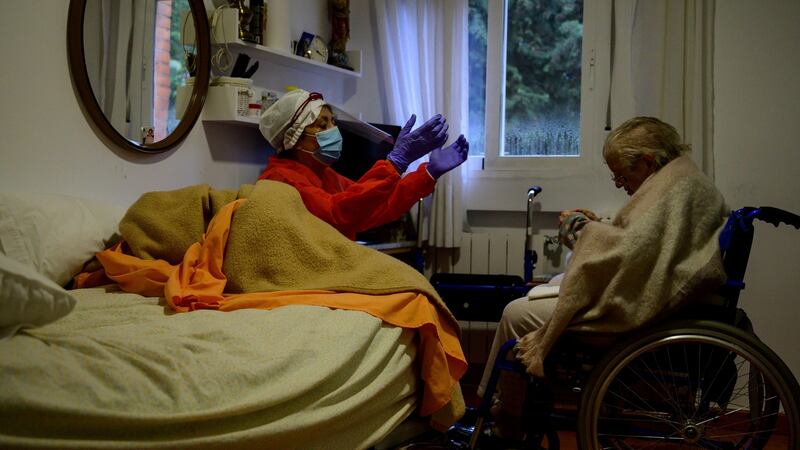 An employee prays with a woman at the Las Praderas care home for the elderly in Pozuelo de Alarcon near Madrid. Photograph: Pierre-Philippe Marcou/AFP via Getty Images