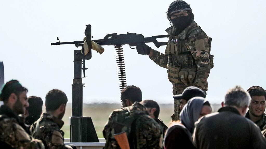 Fighters with the US-backed Syrian Democratic Forces gather at a scanning area for people evacuated from Baghouz. Photograph: Getty Images