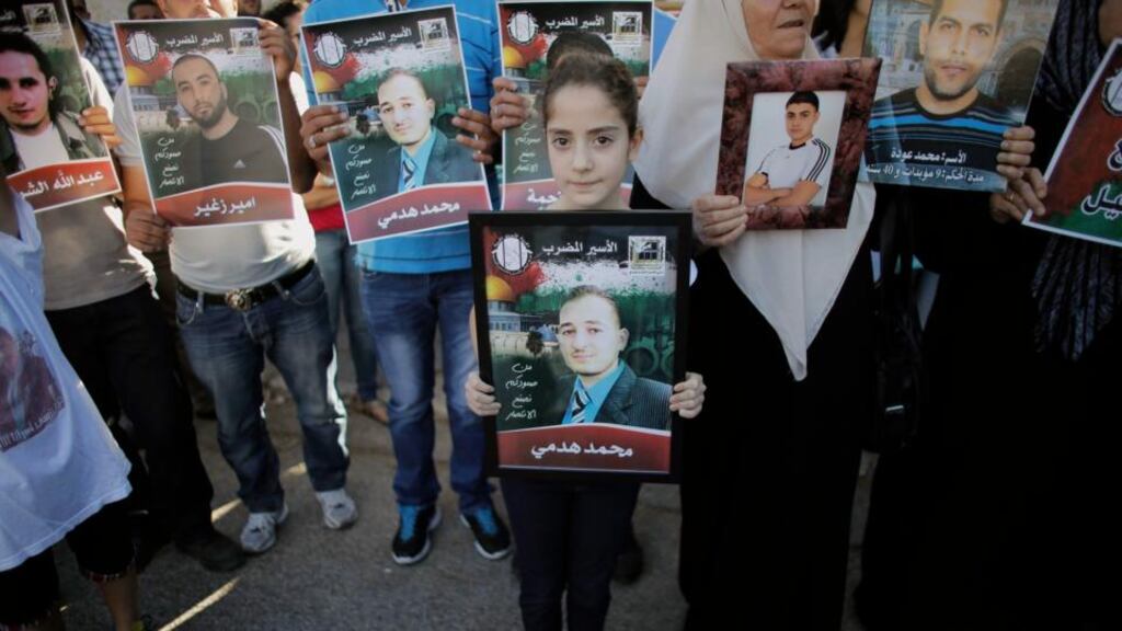 A girl holds a placard depicting her relative during a demonstration to show solidarity with hunger-striking Palestinian prisoners. Photograph: Ammar Awad/Reuters