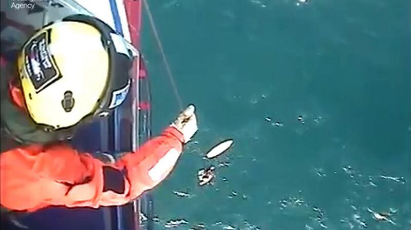 The moment surfer Matthew Bryce, who survived more than 30 hours stranded at sea on his board, was rescued. Photograph: Maritime & Coastguard Agency/PA