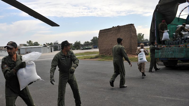 Pakistani soldiers load food bags for earthquake survivors onto an army helicopter. Photograph: Hasham Ahmed/AFP/Getty Images