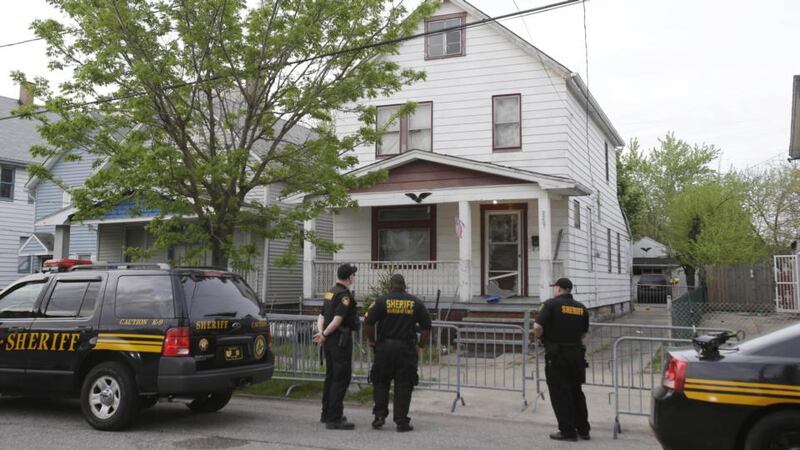 Sheriff deputies stand outside a house in Cleveland, Ohio, following the discovery there  of three women who vanished a decade ago. Photograph: AP Photo/Tony Dejak