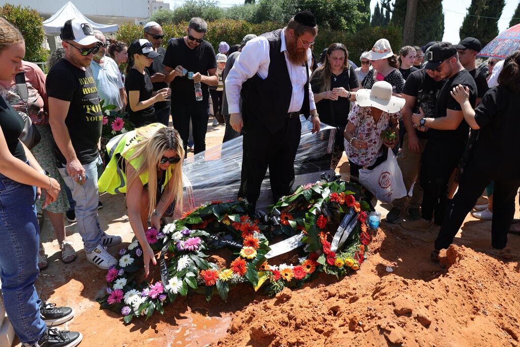 Mourners lay wreaths over the grave of Yevgeny Ferder, who was killed by a Houthi drone attack on Tel Aviv. Photograph: EPA